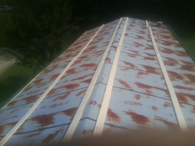 Rusted metal roof panels with new wood purlins before replacement — Storm Damage Roof Repair in La Plata by Roofing Brothers